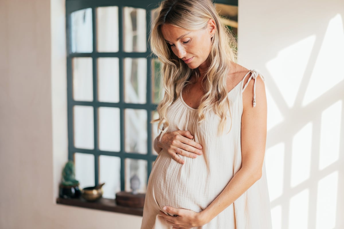 Expectant mother gently touching her belly, representing pregnancy chiropractic care for Plano, TX moms