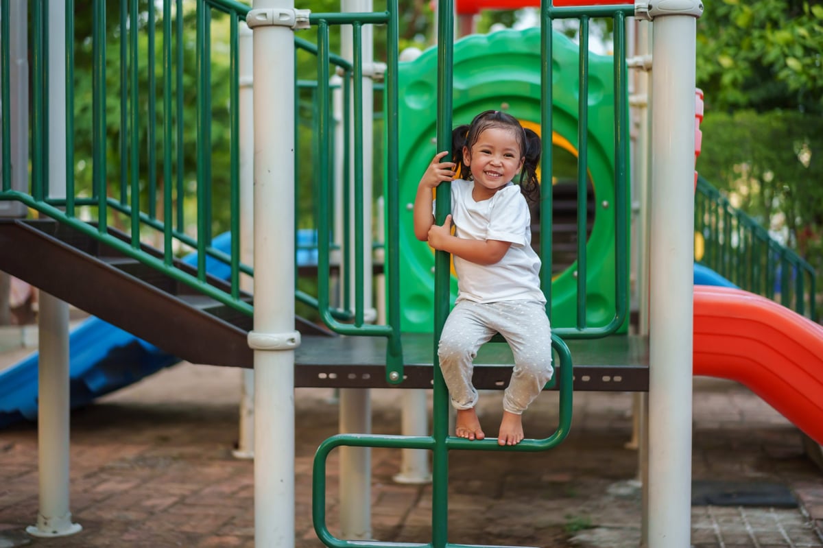 A child climbing on an outdoor playground in Allen, TX